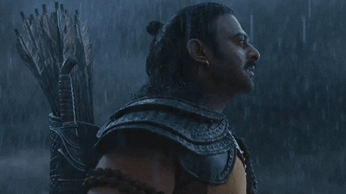 a man in armor is holding a bow and arrows in the rain