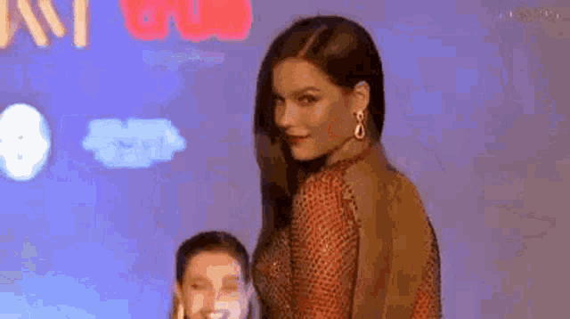 a woman in a red dress is standing next to a girl in a red dress .