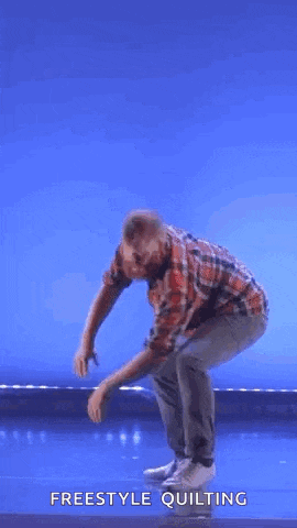 a man in a plaid shirt is standing on a stage with a blue background .