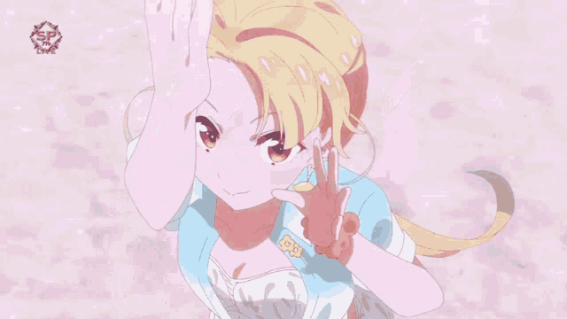 a girl with blonde hair is making a heart shape with her hands in front of a sign that says sp