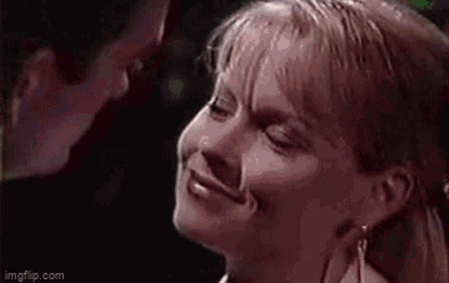 a man and a woman are looking at each other . the woman is smiling and the man is looking at her .