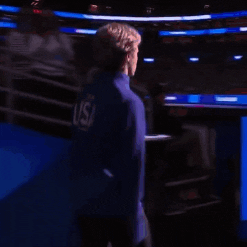 a man stands in front of a screen that says ' men 's skating ' on it