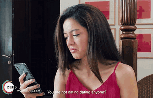 a woman in a red top is looking at a cell phone with the words " you are not dating dating anyone " below her