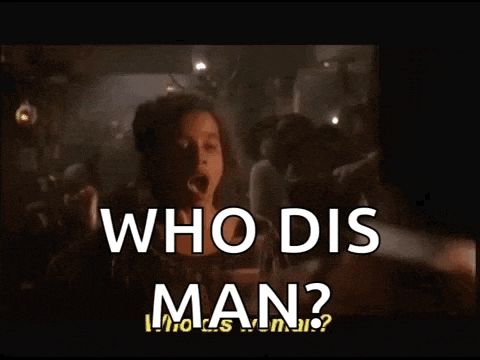 a woman stands in front of a crowd and says who dis man ?