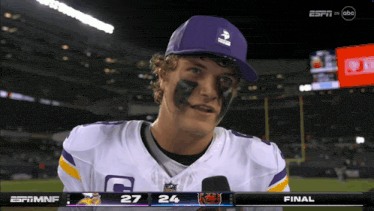 a football player wearing a purple hat and a jersey with the letter c on it
