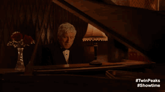 a man in a tuxedo is playing a piano with #twinpeaks #showtime on the bottom
