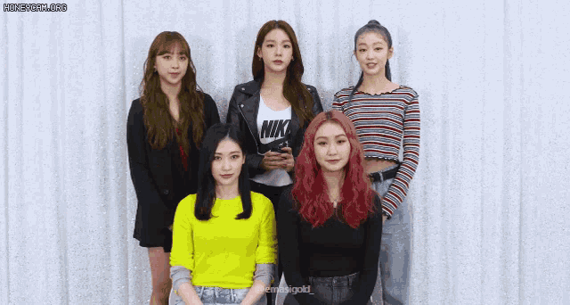 a group of girls are posing for a picture and one of them has a nike shirt on