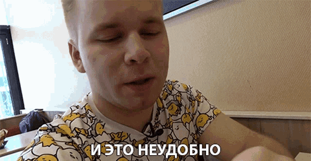a man wearing a yellow and white t-shirt with eggs on it