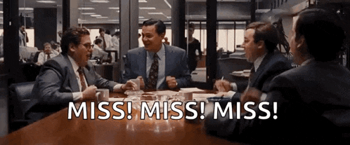 a group of men are sitting at a table with the words miss miss miss written on the table .