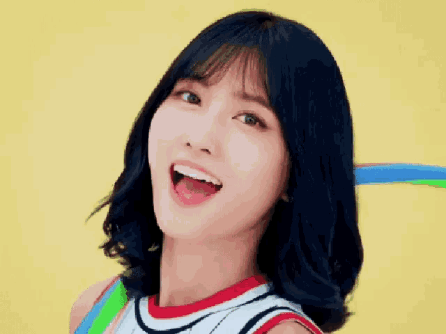 a woman with short black hair is smiling with her mouth open .