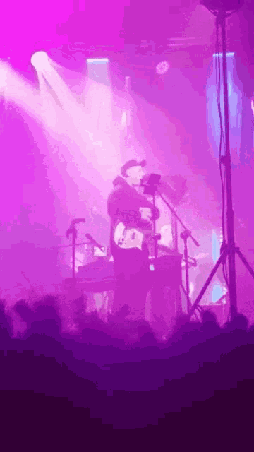 a man in a cowboy hat sings into a microphone while playing a guitar