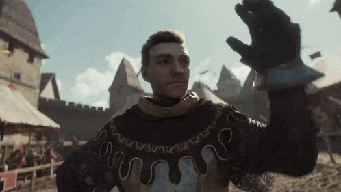 a man in a medieval costume is holding up his glove