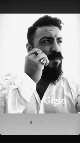 a man with a beard and mustache is wearing a ring and the name gigio is on the bottom