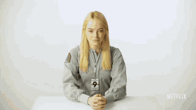 a man is sitting at a desk with his eyes closed and a name tag that says netflix on it