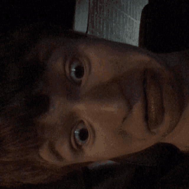a close up of a person 's face with their eyes looking at the camera