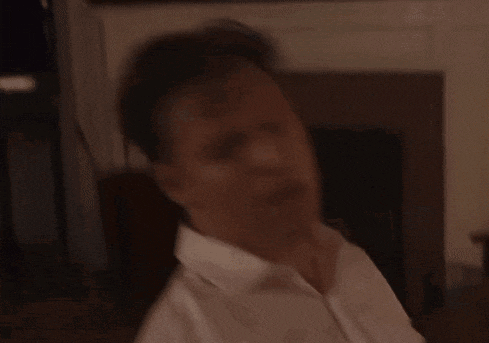 a man in a white shirt holds a microphone in his hand