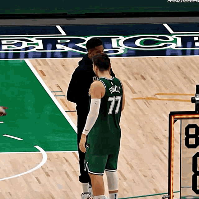 a basketball player wearing a green jersey with the number 77