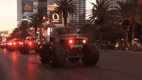 a monster truck is driving down a street in front of a circus of brazil sign