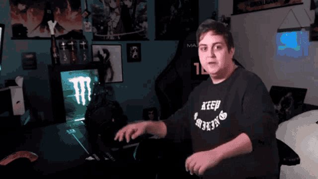 a man wearing a shirt that says keep fighting stands in front of a monster energy sign