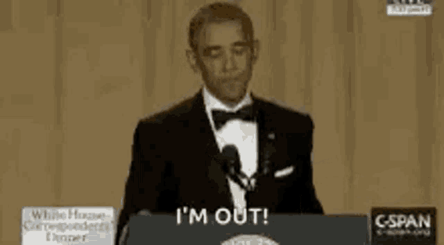 barack obama is giving a speech in front of a microphone and says i 'm out .