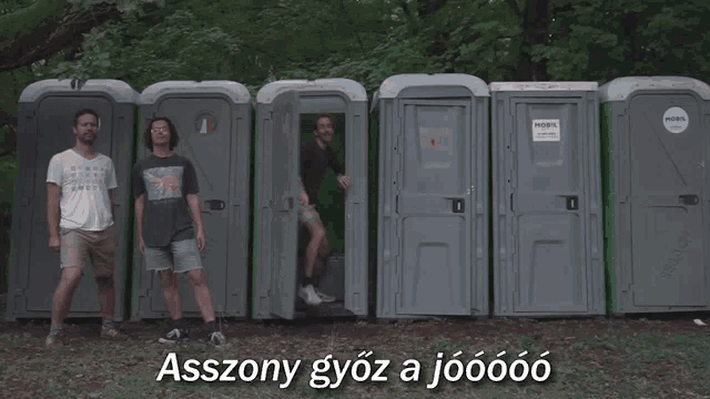 a group of men are standing in front of portable toilets with the words asszony gyoz a jooooo on the bottom right