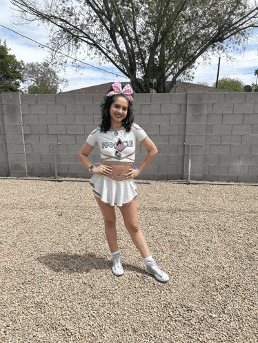 a cheerleader wearing a shirt that says prince is standing in front of a brick wall