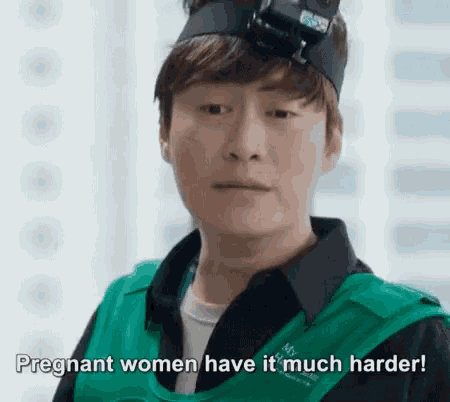a man wearing a headband and a green vest is talking about pregnant women having it much harder .