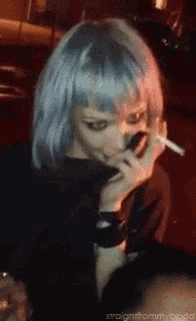 a woman smoking a cigarette with the words straightfrommyblood written below her