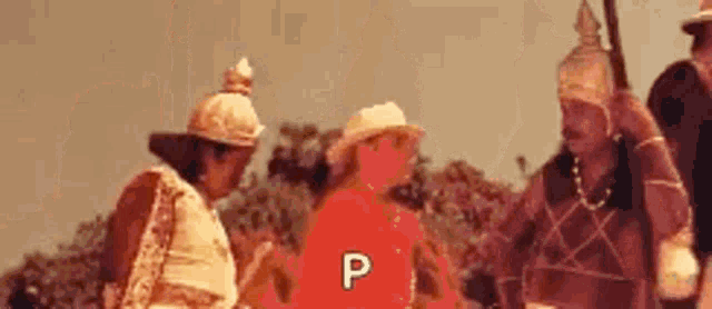 a group of people are standing next to each other in a field with the letter p on the bottom .