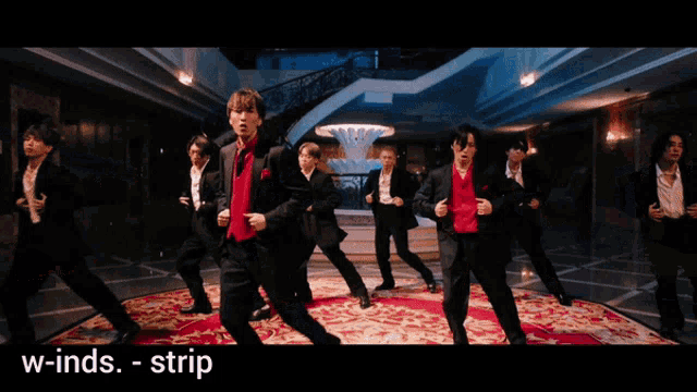 a group of men in suits are dancing in a hallway with the words w-inds - strip on the bottom