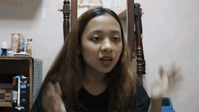 a woman sitting in front of a mirror with a bottle of axe on it