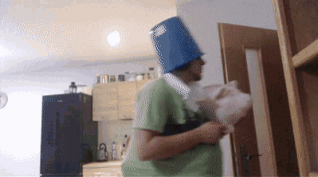 a man wearing a blue bucket hat and a green shirt is holding a piggy bank