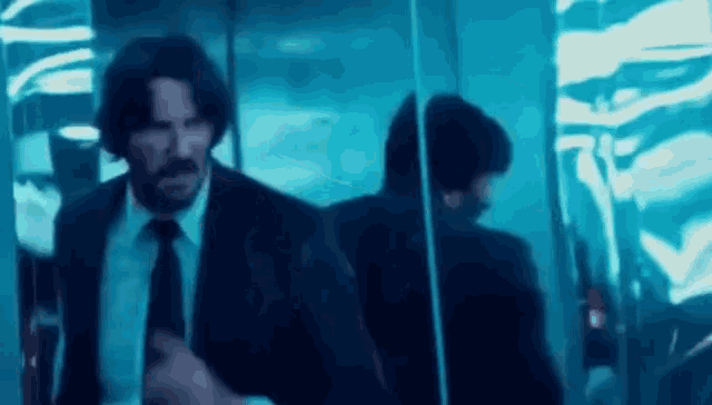 a man in a suit and tie is standing in an elevator .