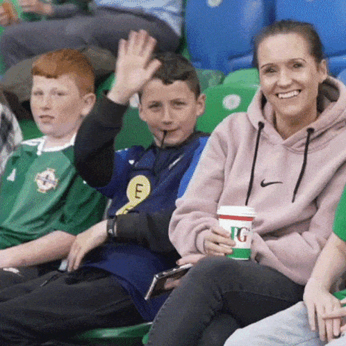 a woman in a pink nike sweatshirt holds a cup of tg