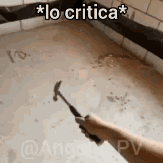 a person is holding a hammer in a room with a caption that says `` lo critica '' .