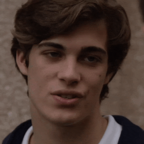 a close up of a young man 's face with a serious look on his face .