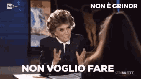 a woman is sitting at a table talking to another woman and the words non voglio fare are visible