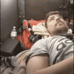 a man is laying on a bed with a backpack and a bottle of coca cola in the background .