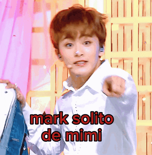 a young man in a white shirt points at the camera with the words mark solito de mimi below him