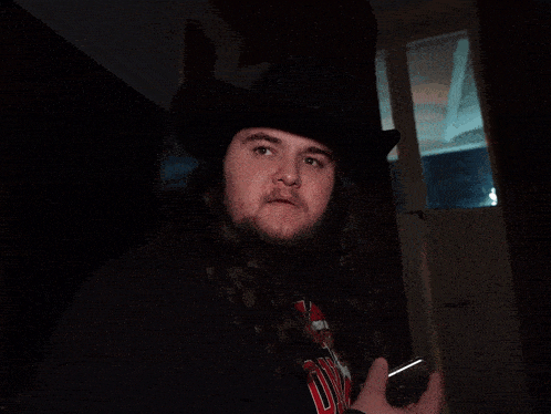 a man with a beard is holding a cell phone and says it said banana