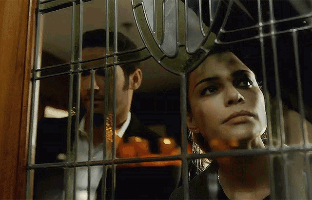 a man and a woman are looking through a window