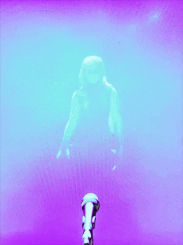 a person is standing in front of a microphone in a dark room