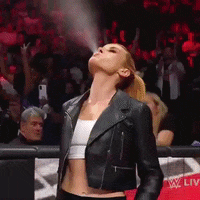 a woman in a black leather jacket is spraying something in the air