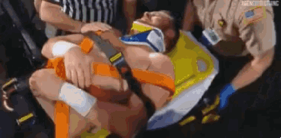 a man is laying on a stretcher with a neck brace on his head .