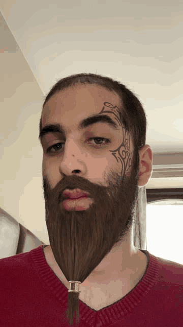 a man with a beard has a tattoo on his face