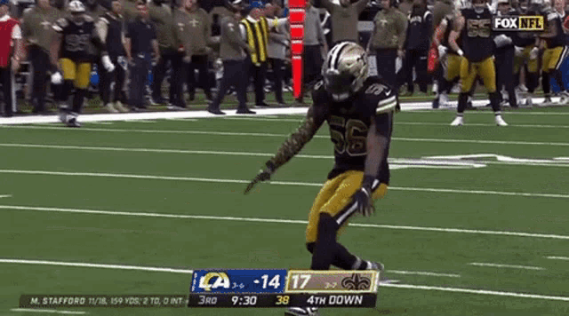 a football player with the number 56 on his jersey is kneeling on the field