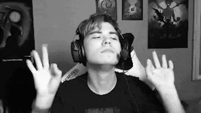 a man wearing headphones is making a peace sign with his hands .
