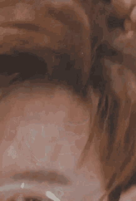 a close up of a woman 's face with a blurred background .
