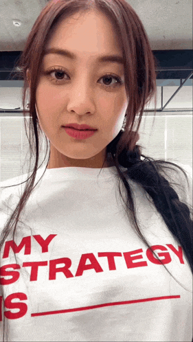a woman is wearing a white shirt that says my strategy is