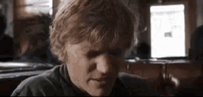 a close up of a man 's face while sitting at a table .